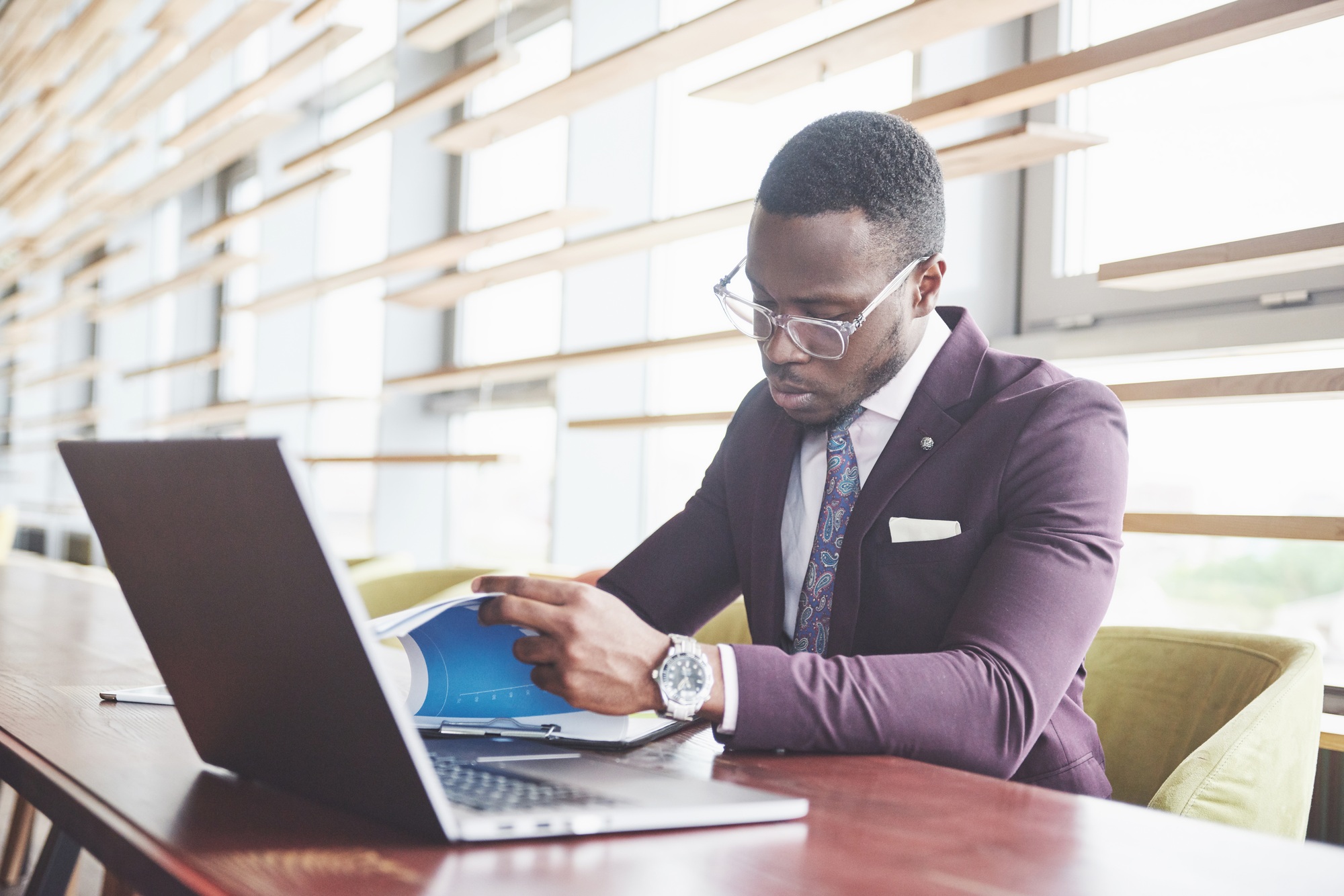 A young businessman signs a contract in a conference room