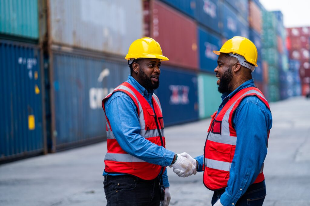 African engineers Supervising loading containers from cargo ships.